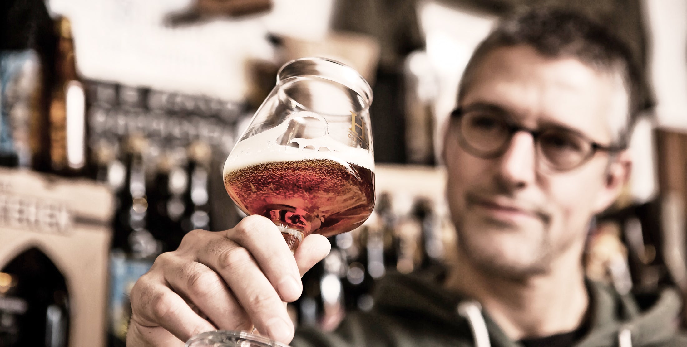 Christian Küppers schwenkt ein Bierglas zur Verkostung
